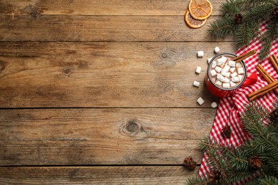 Photo of Flat lay composition of delicious hot chocolate with marshmallows and Christmas decor on wooden table, space for text