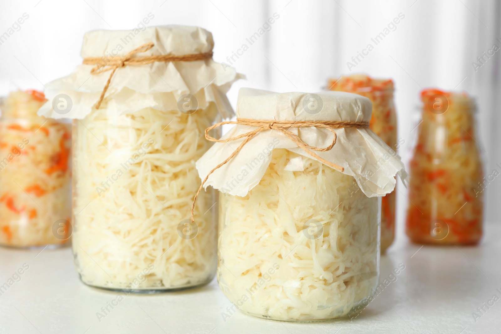 Photo of Tasty homemade fermented cabbage on white table