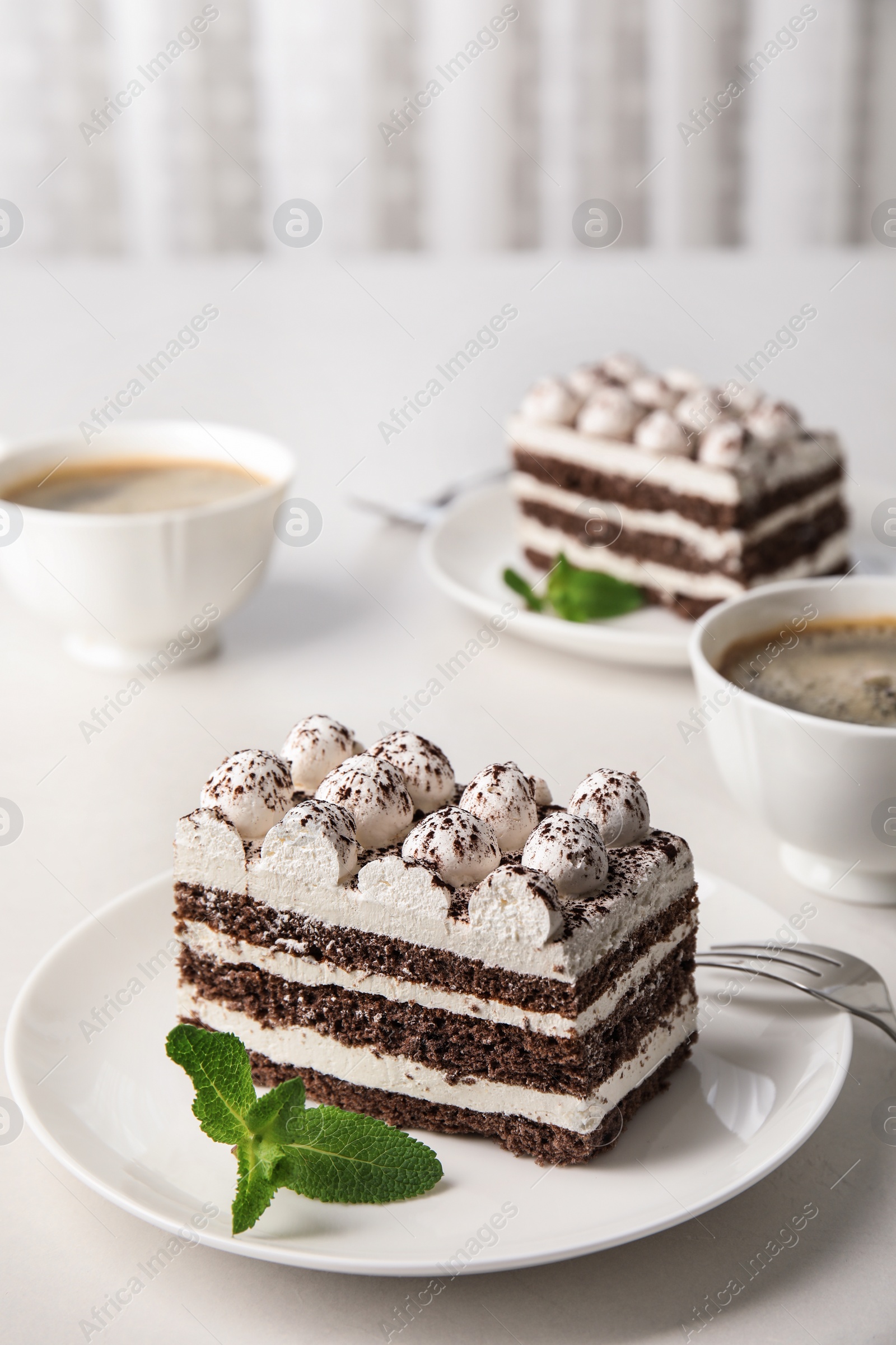 Photo of Composition with tiramisu cakes and mint on table