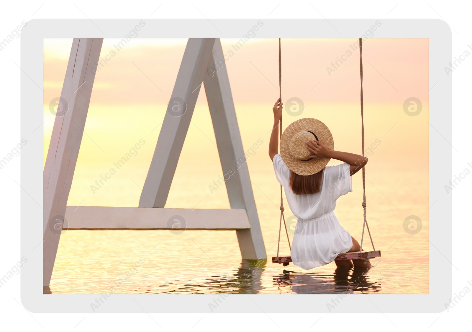 Image of Paper photo. Young woman on swing over water