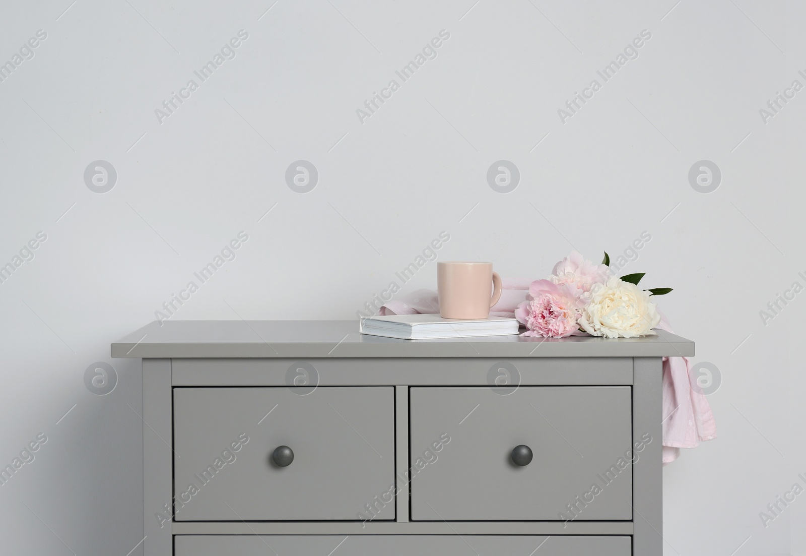Photo of Grey chest of drawers on light background