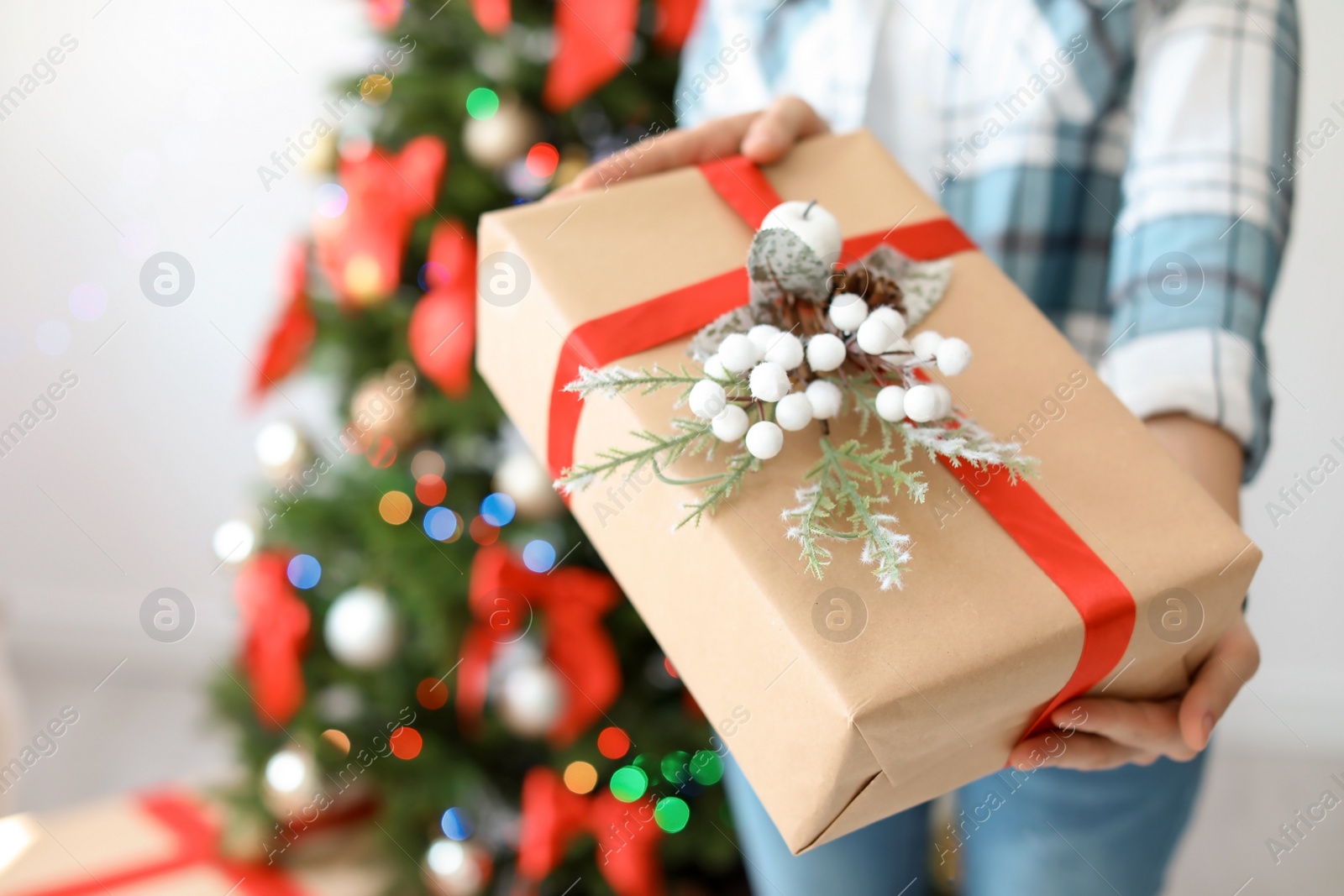 Photo of Young woman with Christmas gift at home