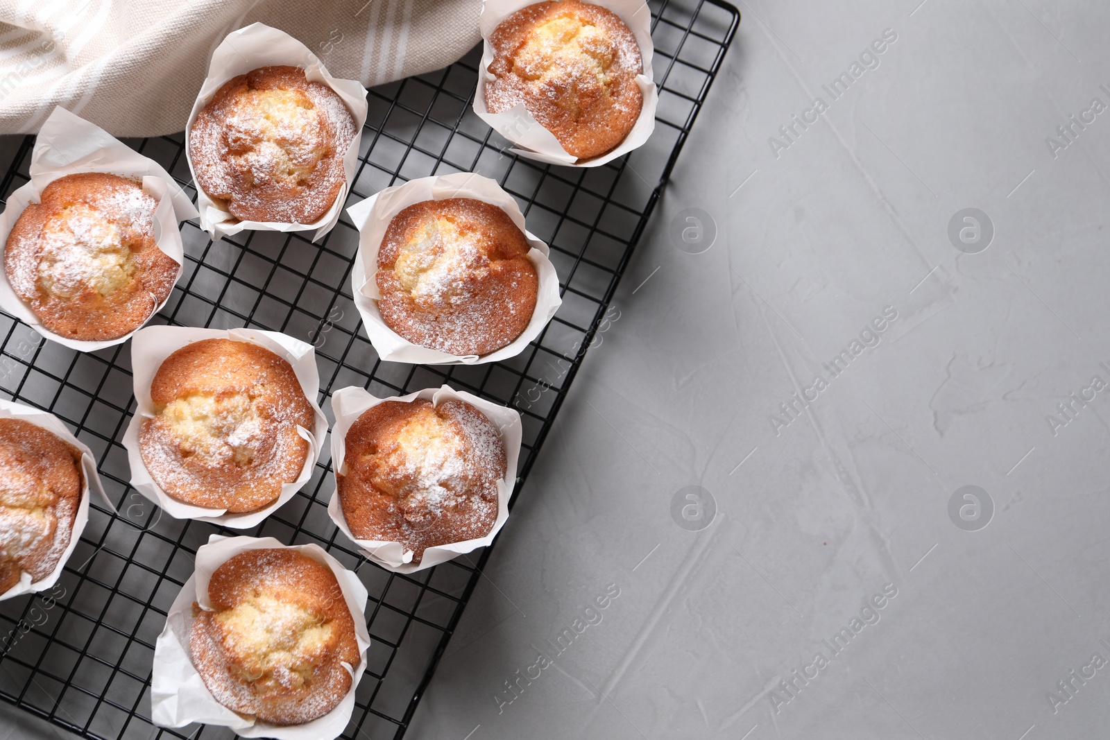 Photo of Delicious muffins on light table, top view. Space for text