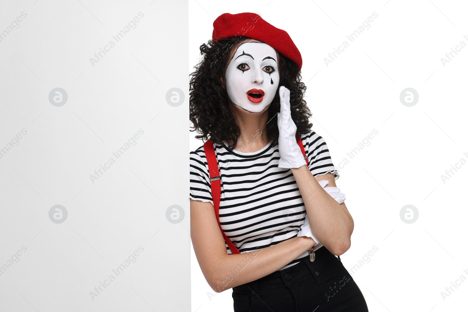 Photo of Funny mime with blank poster posing on white background