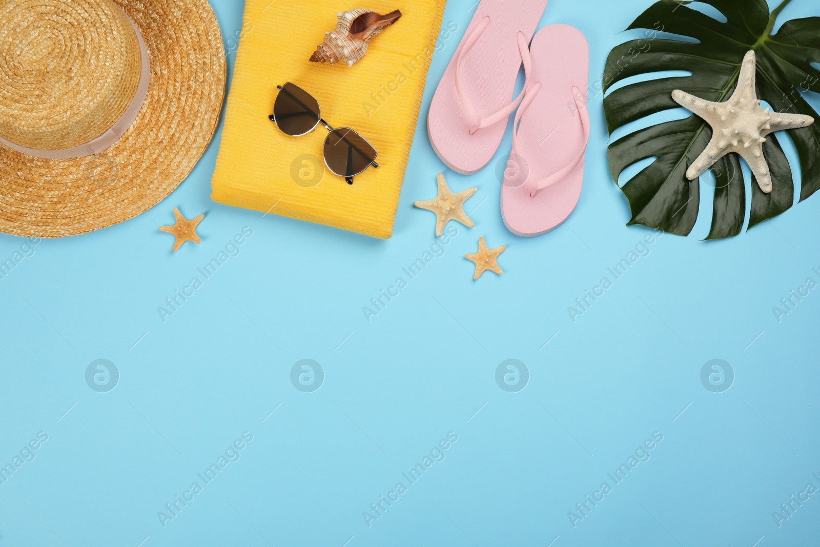 Photo of Flat lay composition with beach objects on light blue background, space for text