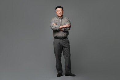 Full length portrait of happy businessman on grey background