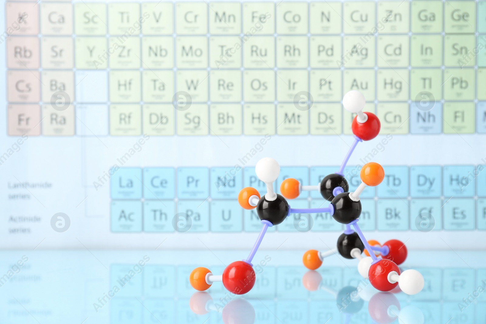 Photo of Molecular model on light surface against periodic table, space for text