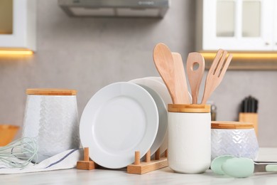 Set of different kitchenware on white table at home