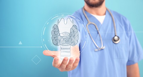 Endocrinologist holding virtual thyroid gland on light blue background, closeup. Banner design