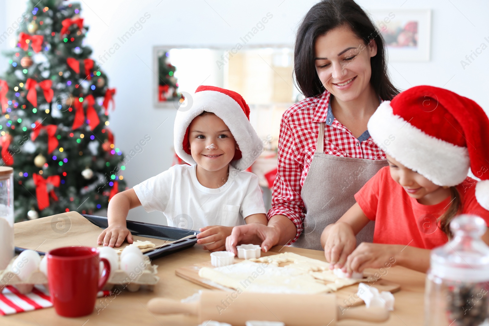 Photo of Mother and children making Christmas cookies together at home