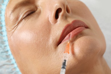 Photo of Senior woman getting lip injection, closeup. Cosmetic surgery