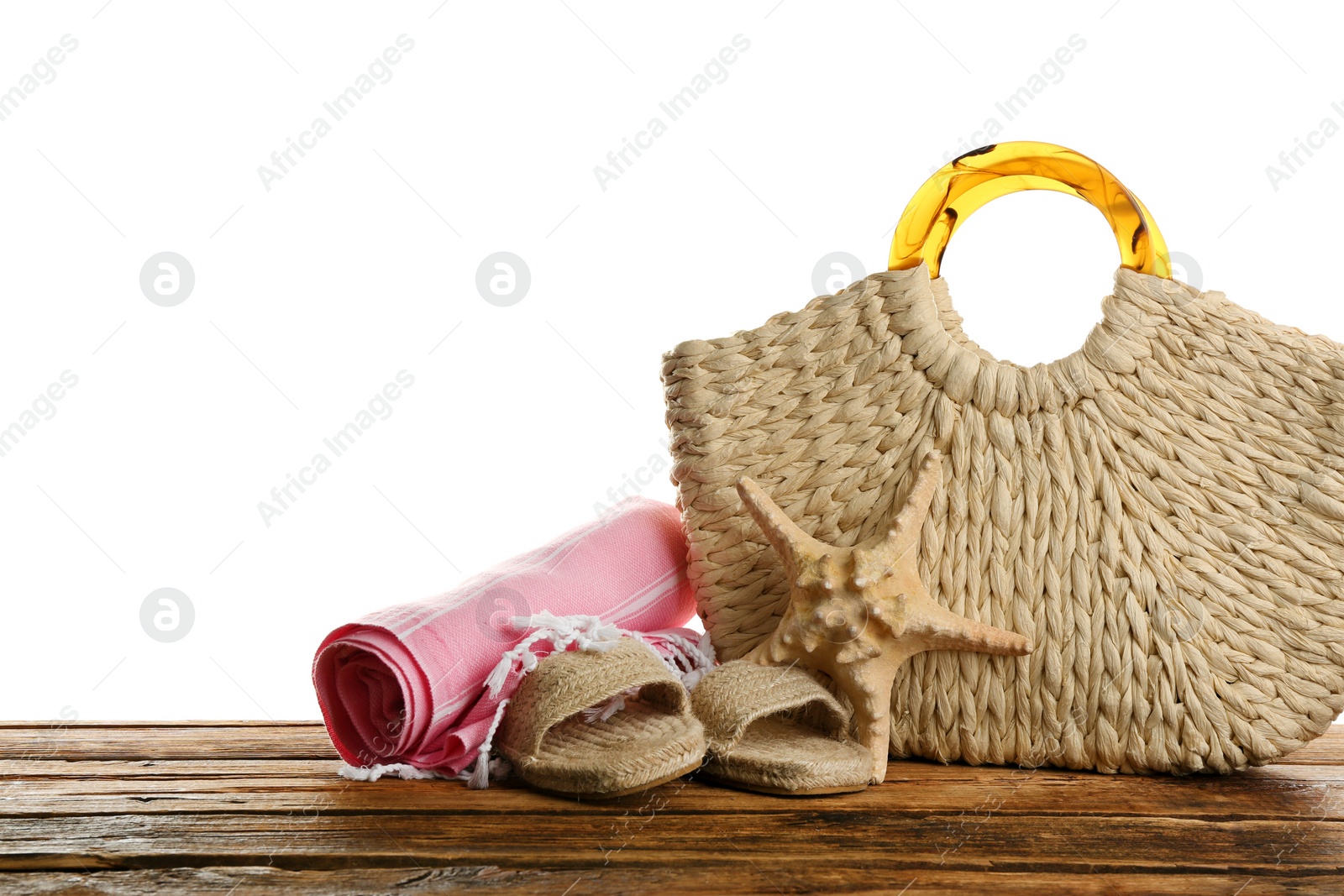 Photo of Stylish bag with beach accessories on wooden table