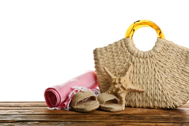 Stylish bag with beach accessories on wooden table