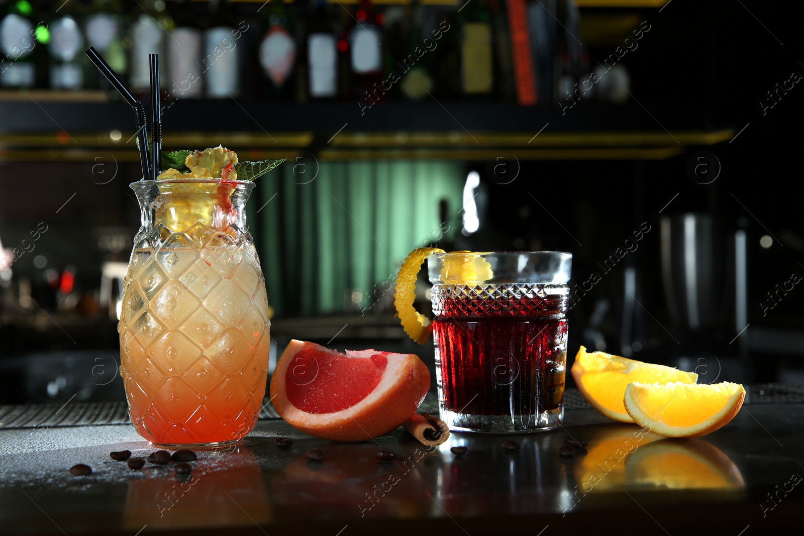 Photo of Fresh alcoholic cocktails in glasses on bar counter
