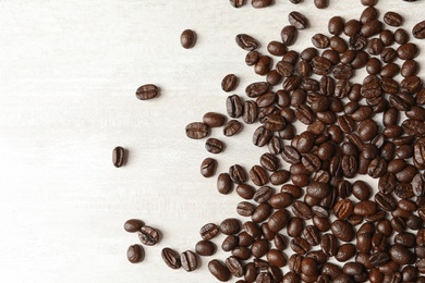 Photo of Roasted coffee beans on white background, top view