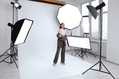 Photo of Beautiful young model posing in modern studio. Professional photo session