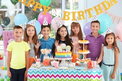 Happy children at birthday party in decorated room