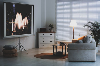 Image of Stylish room with modern video projector and comfortable sofa