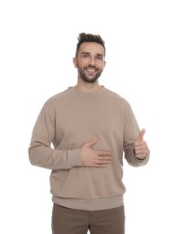 Happy man touching his belly on white background. Concept of healthy stomach