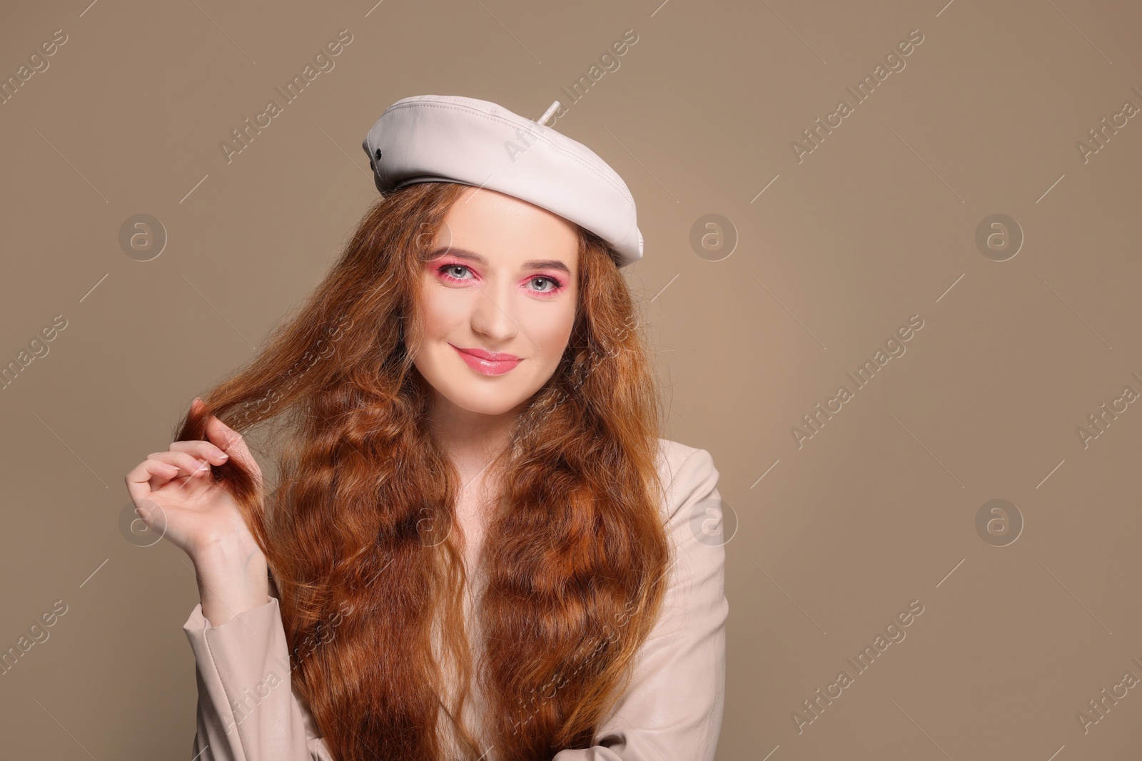 Photo of Portrait of beautiful happy woman with makeup posing on beige background. Space for text