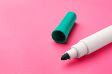 Photo of Bright green marker on pink background, closeup. Space for text