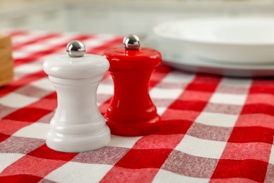 Photo of Ceramic salt and pepper mills on kitchen table. Space for text