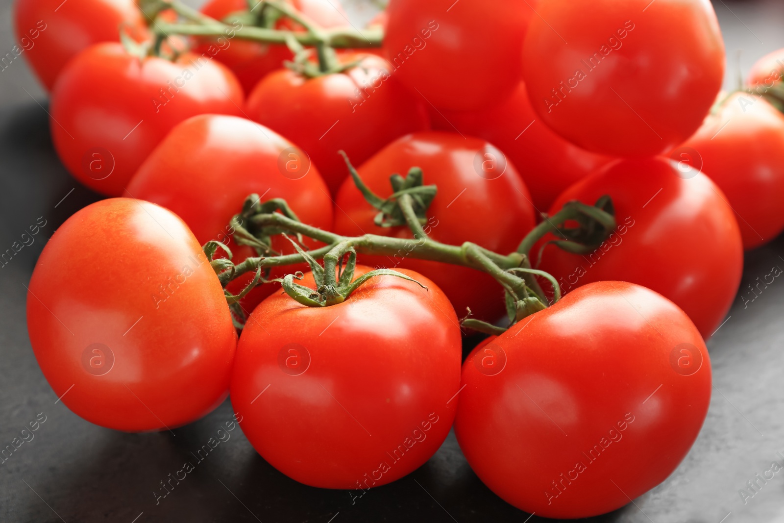 Photo of Slate plate with fresh ripe tomatoes, closeup