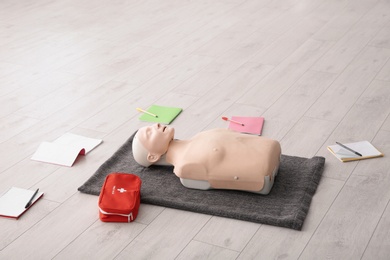 Notebooks, first aid mannequin and bag on floor indoors