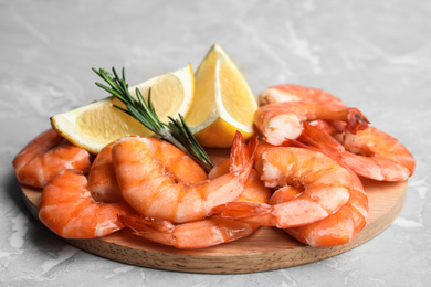 Photo of Delicious cooked shrimps with rosemary and lemon on grey marble table