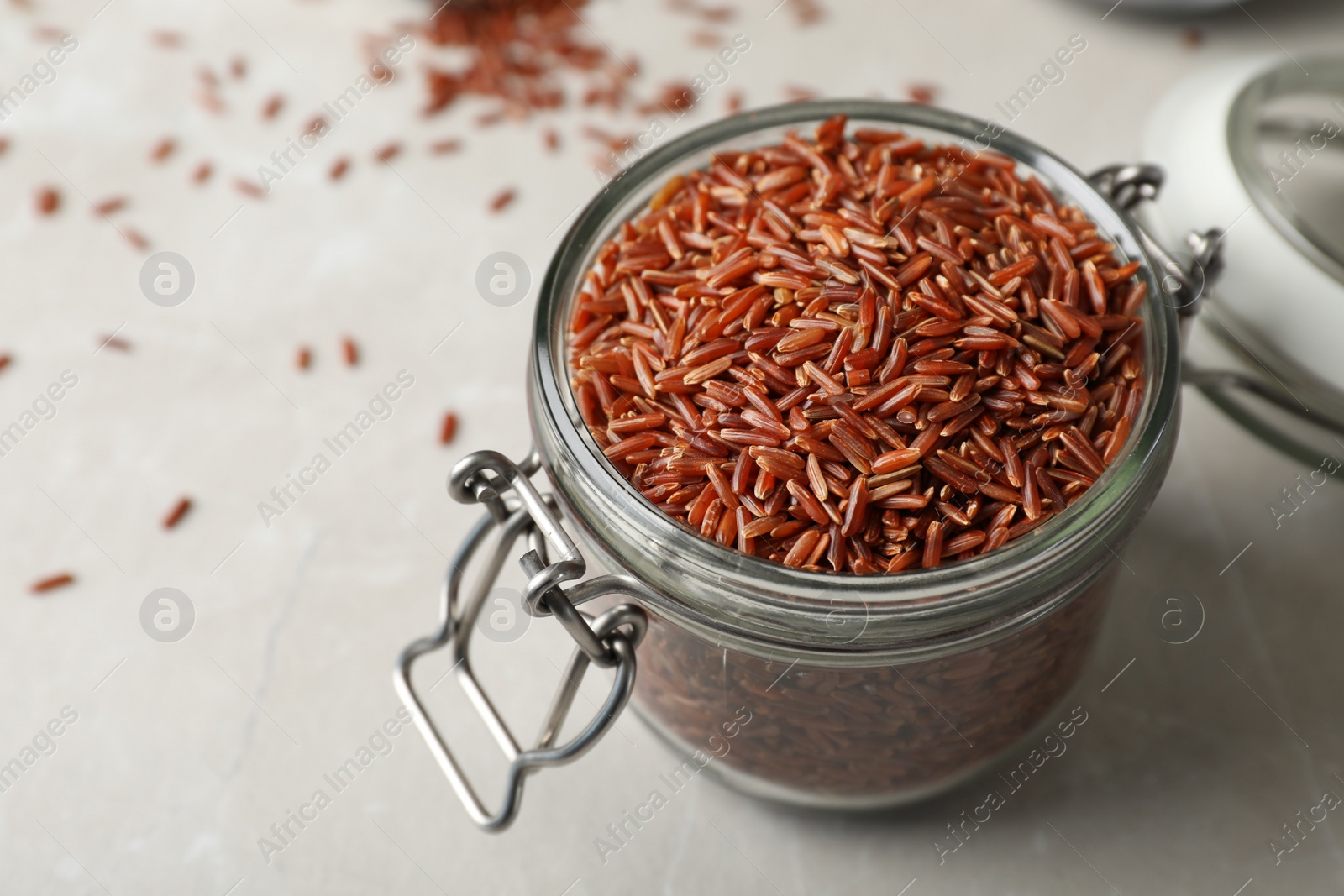 Photo of Brown rice in glass jar on table. Space for text