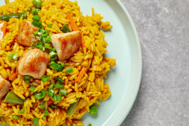 Delicious rice pilaf with vegetables and chicken on light grey table, closeup