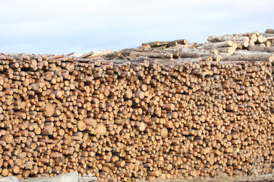 Photo of Stacked firewood outdoors. Heating house in winter