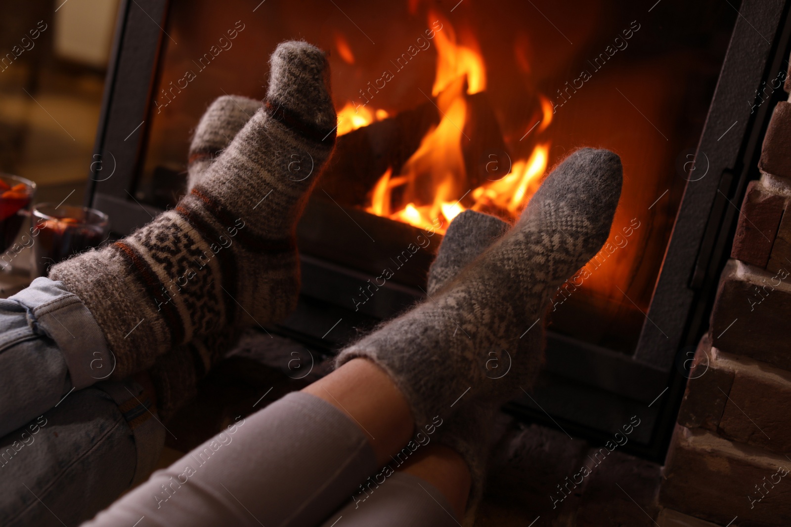 Photo of Couple resting near fireplace indoors, closeup. Winter vacation