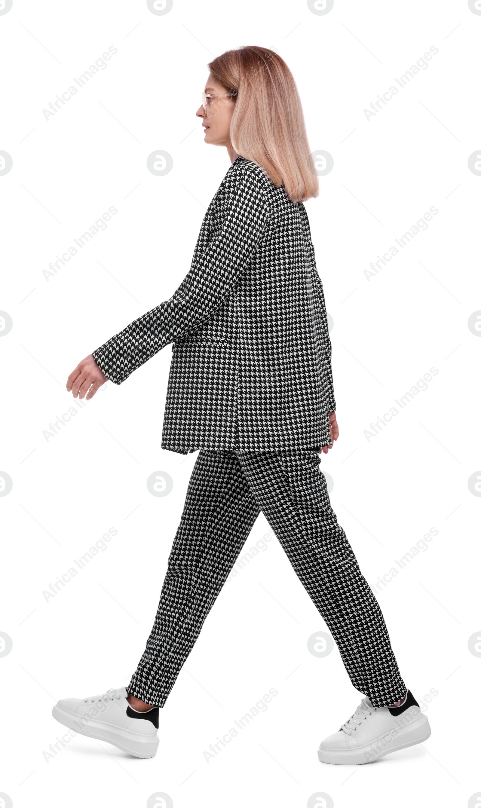 Photo of Beautiful businesswoman in suit walking on white background