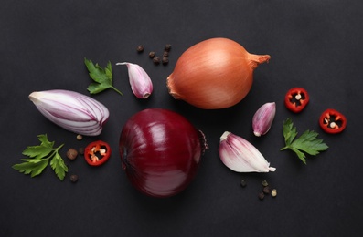 Photo of Flat lay composition with onions and spices on black background