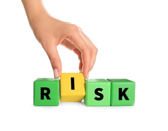 Photo of Woman making word Risk of color wooden cubes on white background, closeup