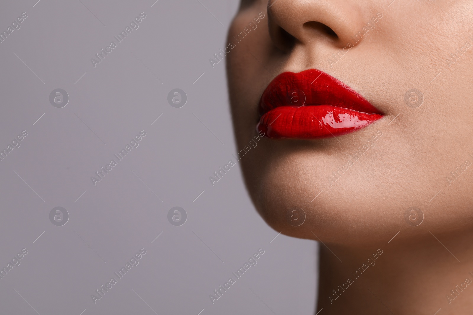 Photo of Closeup view of woman with beautiful full lips on grey background. Space for text