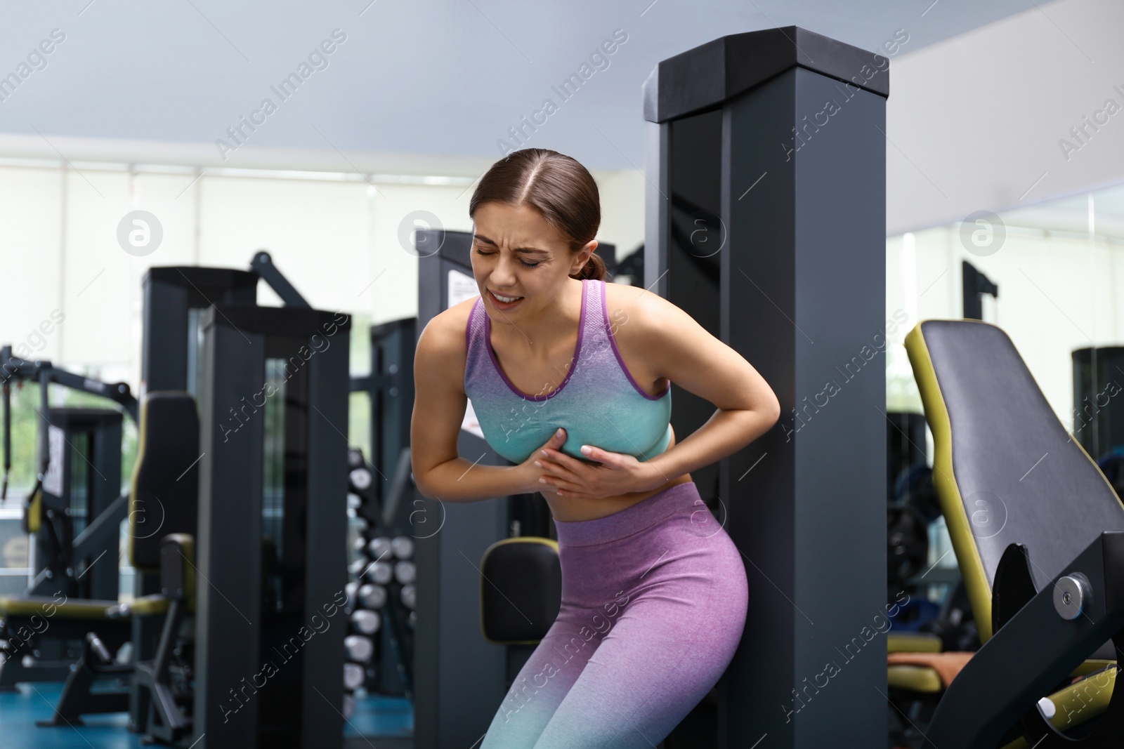 Photo of Young woman having heart attack in gym