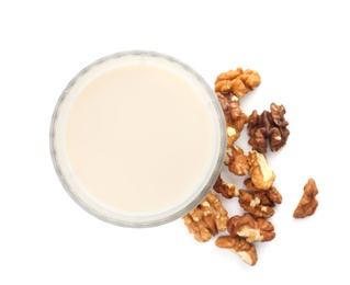 Glass with walnut milk and nuts on white background