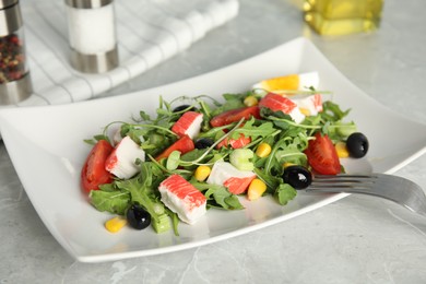 Tasty crab stick salad served on grey marble table