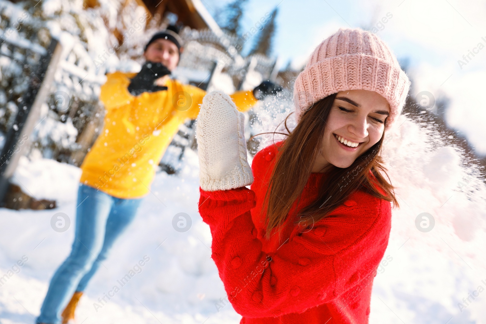 Photo of Happy couple playing snowballs outdoors. Winter vacation