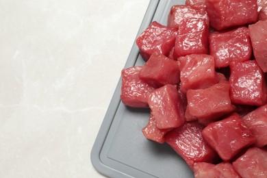 Photo of Cooking delicious goulash. Raw beef meat on light grey table, top view. Space for text