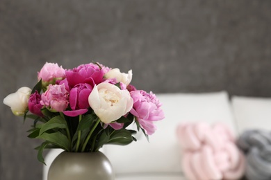 Photo of Vase with bouquet of beautiful peonies in room, space for text