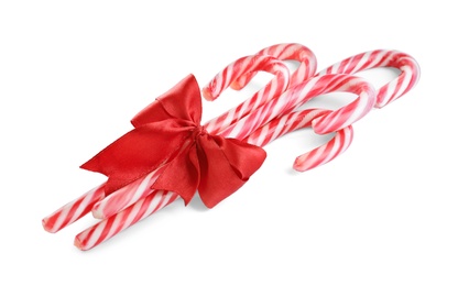 Sweet Christmas candy canes with red bow on white background