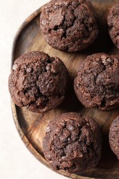 Photo of Board with delicious chocolate muffins on white table, top view