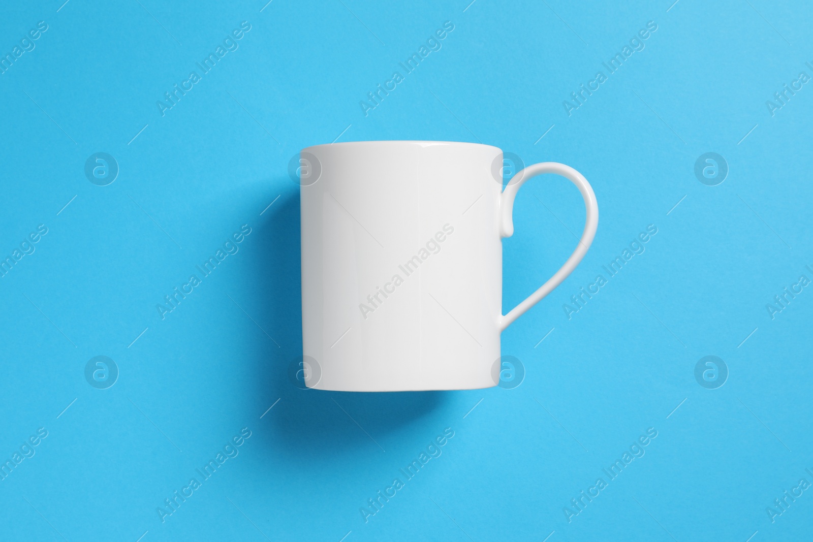 One white ceramic mug on light blue background, top view Photo of One white ceramic mug on light blue background, top view