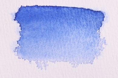 Abstract blue watercolor painting on white paper, top view