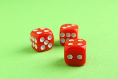 Photo of Three red game dices on green background, closeup
