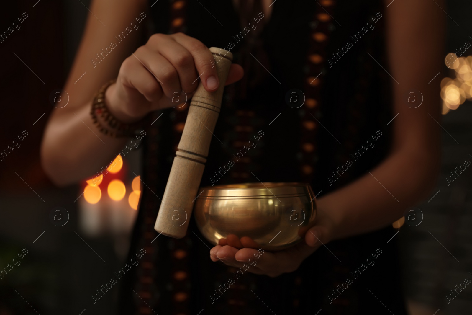 Photo of Healer using singing bowl in dark room, closeup