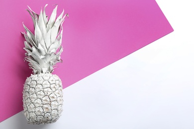 Photo of Pink pineapple on color background, top view with space for text. Creative concept